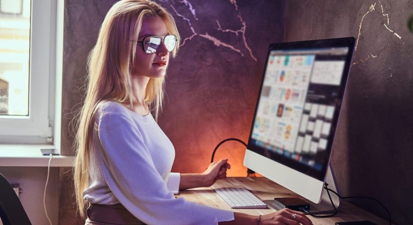 attractive blond girl is studying her modern room using computer scaled 1